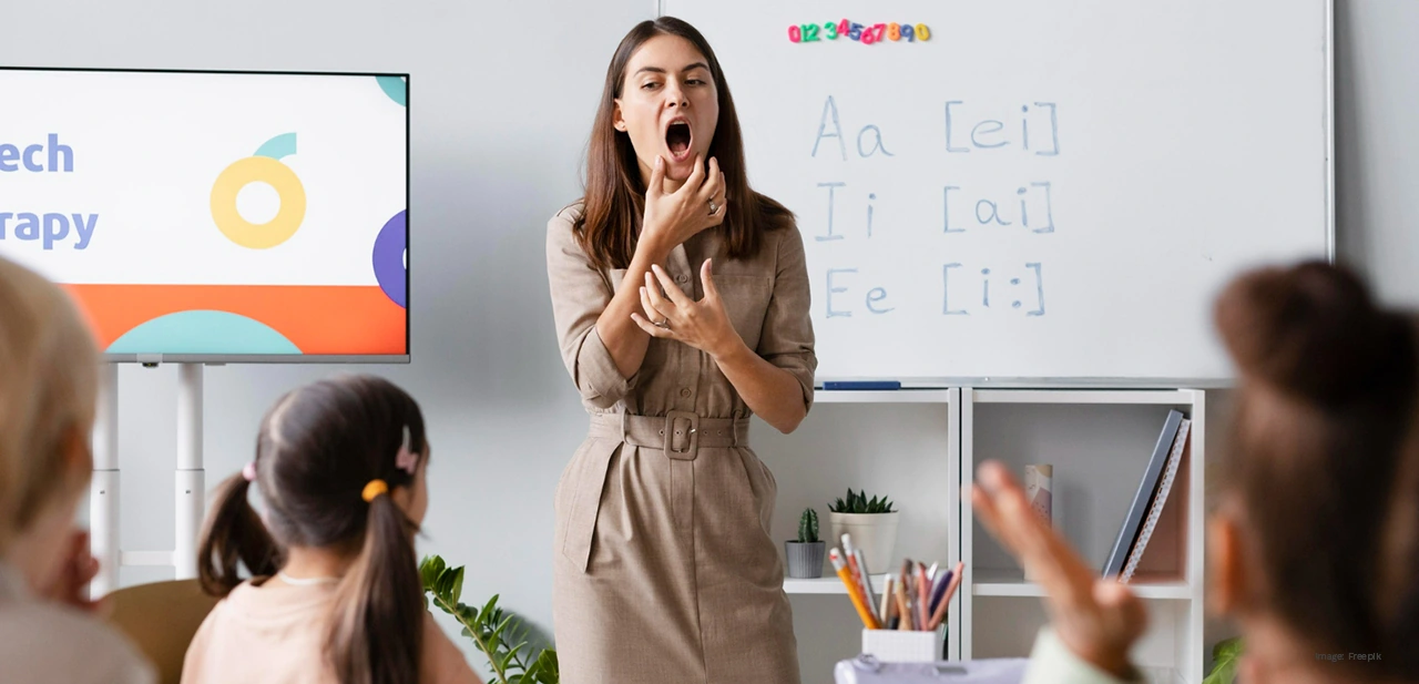 A teacher demonstrating mouth formation with vowel pronunciation