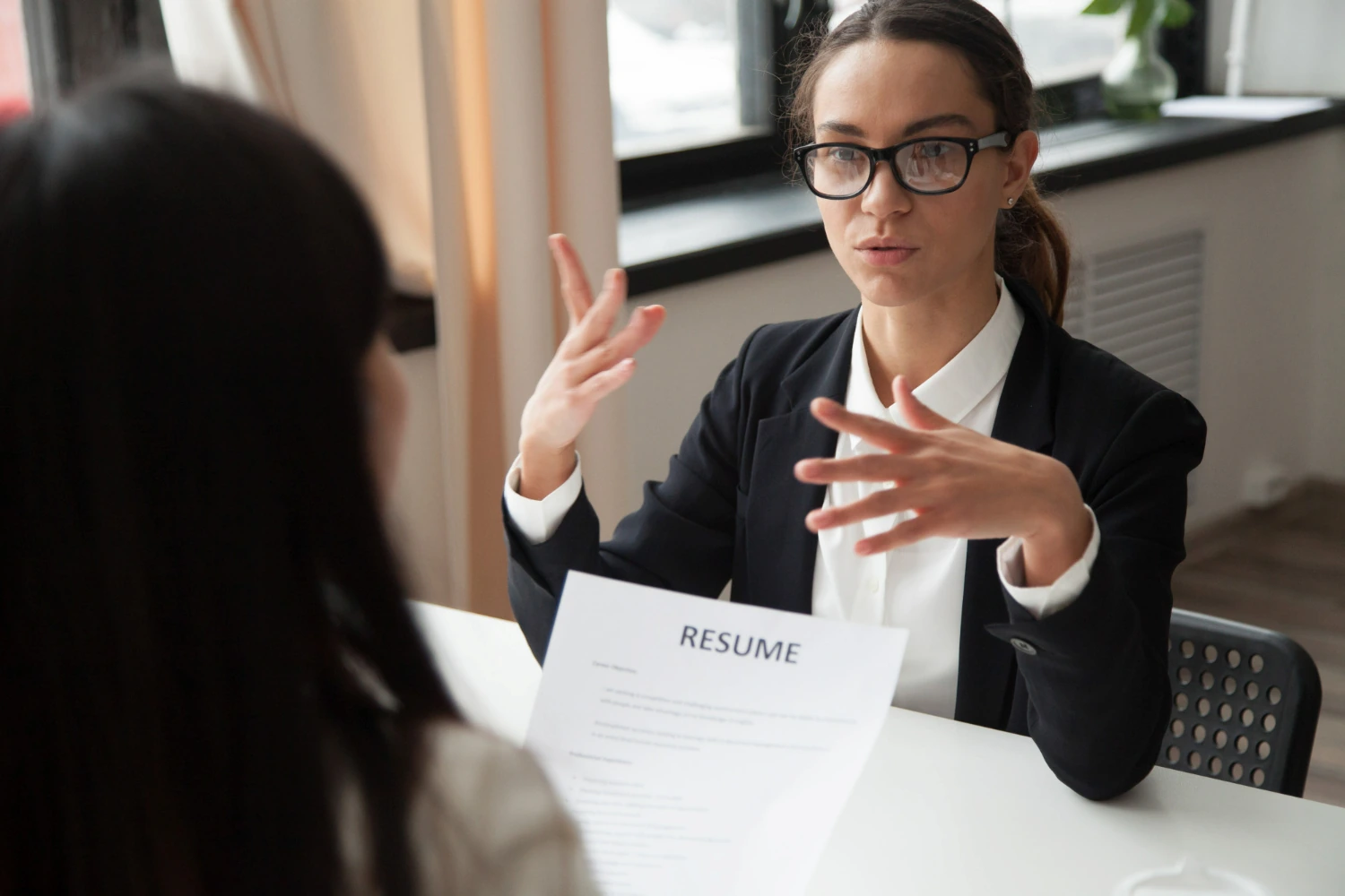 The Complete Guide to Business English for Job Interviews. A young woman interviewing a candidate for a job.